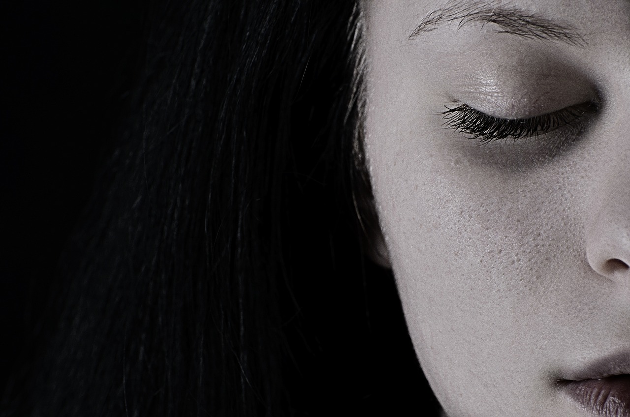 Black and white image of half face of a woman with closed eyes.